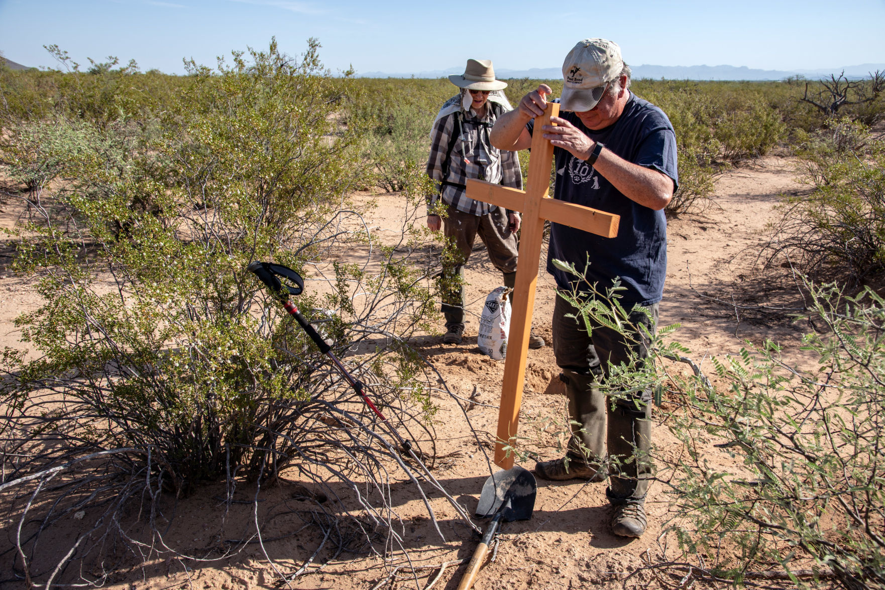 A member of the Tucson Samaritans, here artist Ron Kovatch (left), helps Alvaro Enciso (right) to place a cross where the remains of a migrant were found. Location Sonoran Desert, near Tuc.jpg